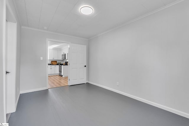 spare room featuring dark wood-type flooring and crown molding