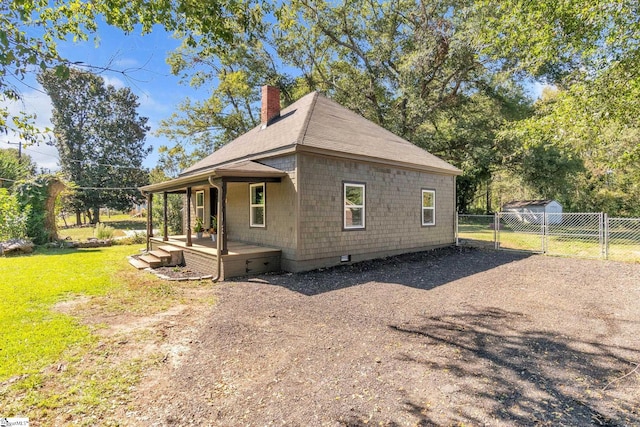 view of home's exterior featuring a porch and a lawn