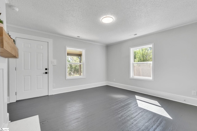 spare room featuring dark hardwood / wood-style floors, a healthy amount of sunlight, and a textured ceiling