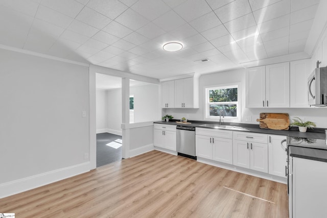 kitchen featuring stainless steel appliances, sink, light hardwood / wood-style flooring, crown molding, and white cabinets