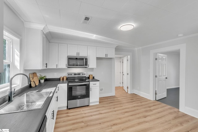 kitchen featuring stainless steel appliances, sink, crown molding, white cabinetry, and light hardwood / wood-style flooring