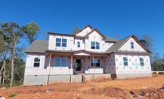 property in mid-construction with covered porch and a shingled roof