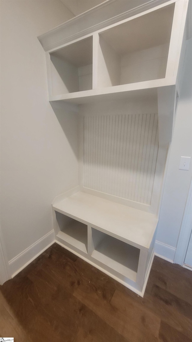 mudroom with dark wood-style floors and baseboards