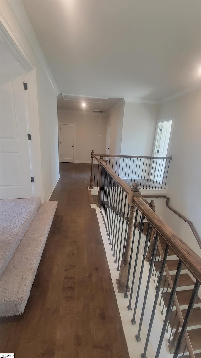 hall featuring attic access, an upstairs landing, crown molding, and baseboards