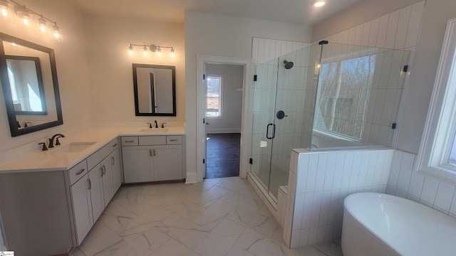 bathroom featuring marble finish floor, double vanity, a sink, and a shower stall