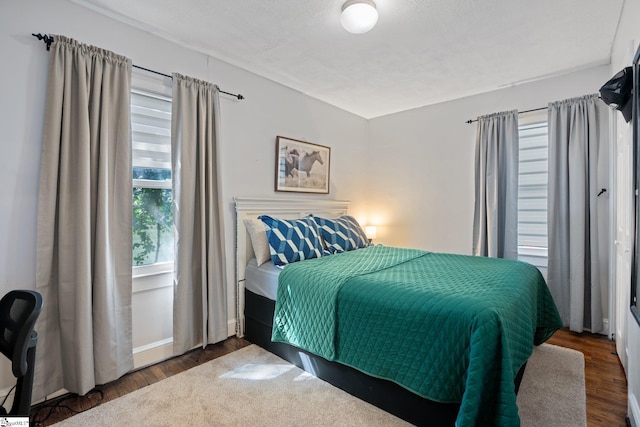 bedroom with a textured ceiling and dark hardwood / wood-style floors