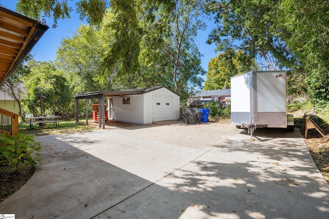 view of patio featuring a garage and an outbuilding