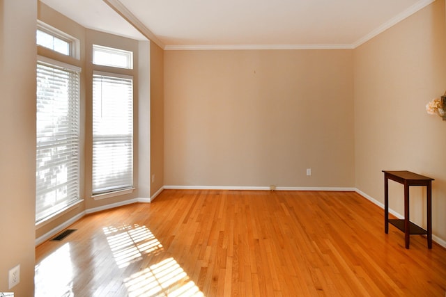 empty room with light wood-type flooring and crown molding