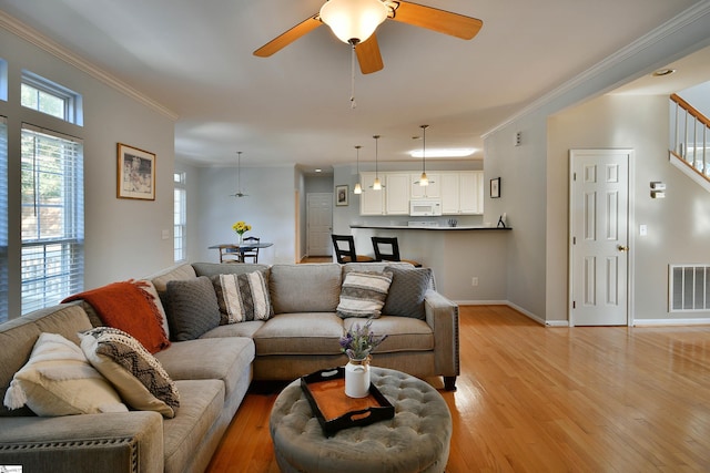 living room with ceiling fan, crown molding, and light hardwood / wood-style floors