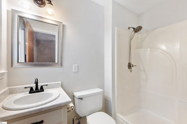 bathroom featuring a shower, vanity, and toilet