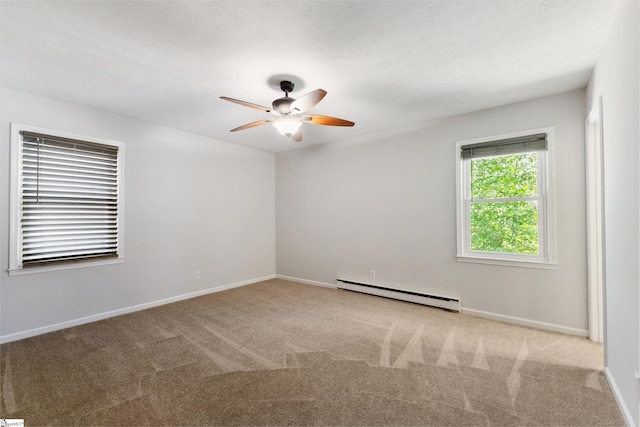 spare room featuring light colored carpet, a baseboard heating unit, and ceiling fan