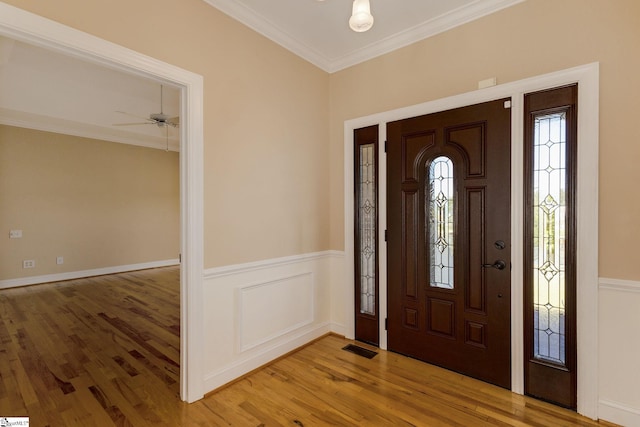 foyer featuring ornamental molding, ceiling fan, and wood-type flooring