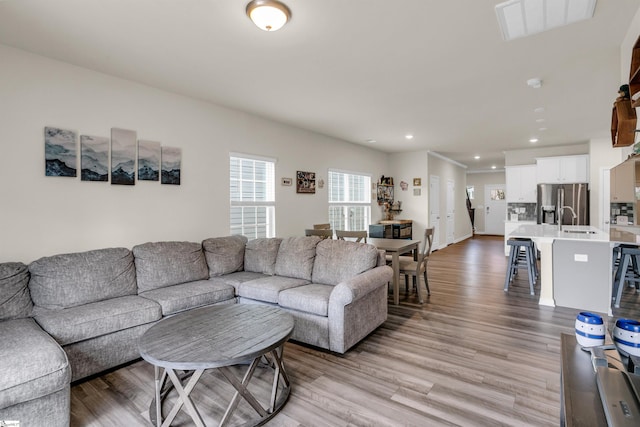 living room with light hardwood / wood-style floors and sink