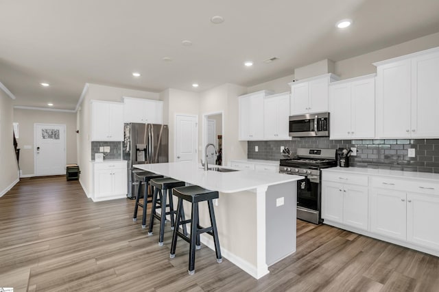 kitchen with white cabinets, a center island with sink, stainless steel appliances, and sink