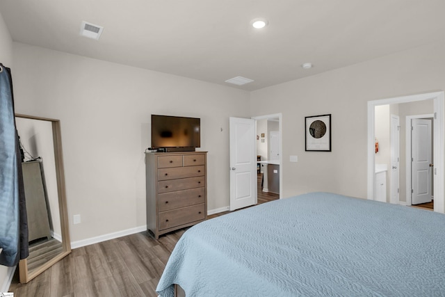 bedroom featuring light wood-type flooring and ensuite bath