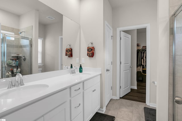 bathroom featuring vanity, a shower with shower door, toilet, and tile patterned floors