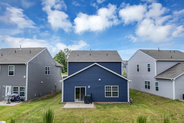 back of property with a yard and a patio area