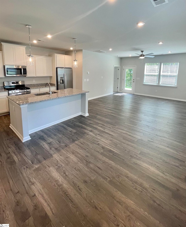 kitchen featuring a center island with sink, sink, white cabinetry, appliances with stainless steel finishes, and dark hardwood / wood-style floors