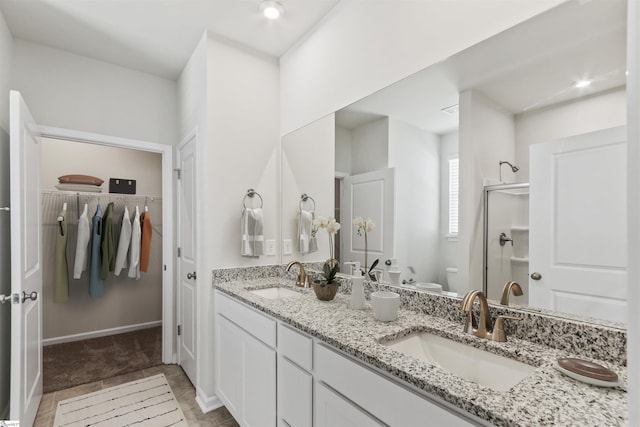 bathroom with a shower with shower door, vanity, and toilet