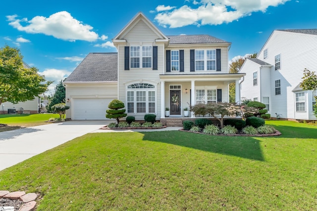 colonial house with a front yard, a garage, and covered porch