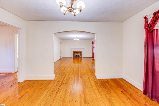 hall with hardwood / wood-style flooring, a notable chandelier, and a textured ceiling