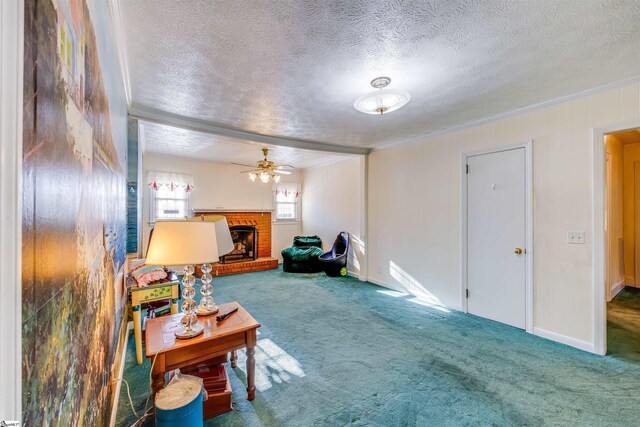 carpeted living room featuring ornamental molding, a fireplace, ceiling fan, and a textured ceiling