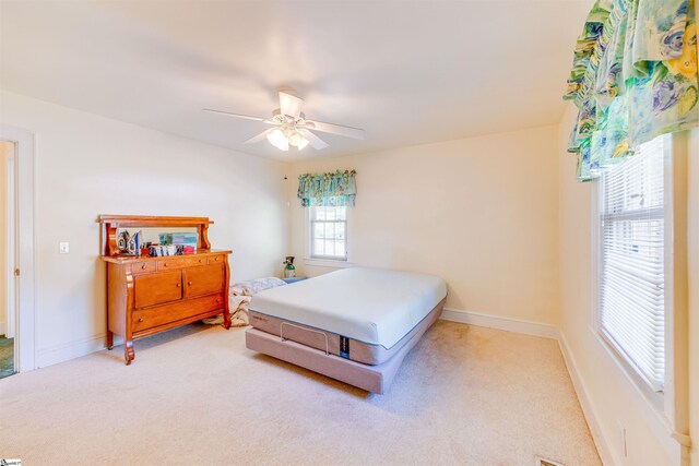 bedroom featuring light colored carpet and ceiling fan