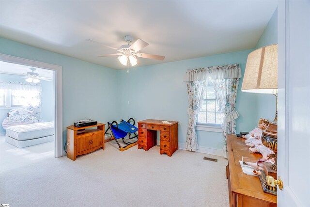 carpeted office with plenty of natural light and ceiling fan