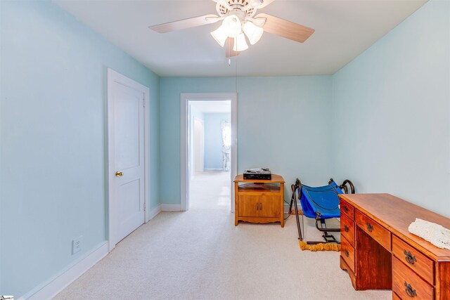 carpeted home office featuring ceiling fan