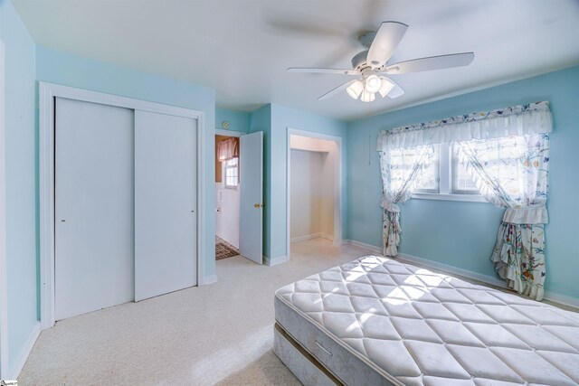 carpeted bedroom featuring ceiling fan and a closet