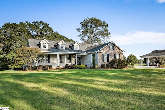 cape cod-style house featuring a front lawn and covered porch