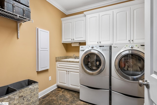 washroom featuring ornamental molding, cabinets, sink, and washer and dryer