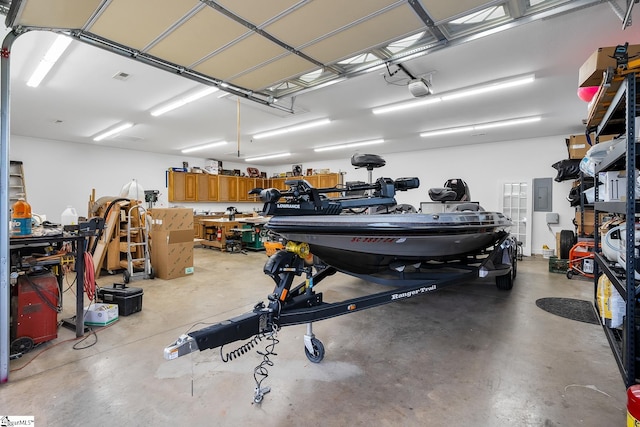 garage featuring a workshop area, electric panel, and a garage door opener