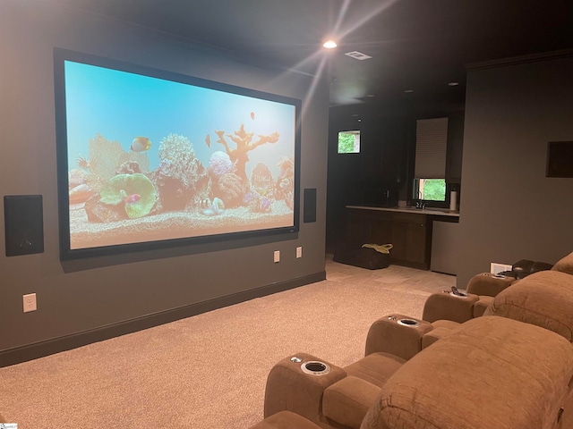 cinema room with light colored carpet and sink