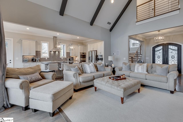 living room with beam ceiling, high vaulted ceiling, a wealth of natural light, and light hardwood / wood-style flooring