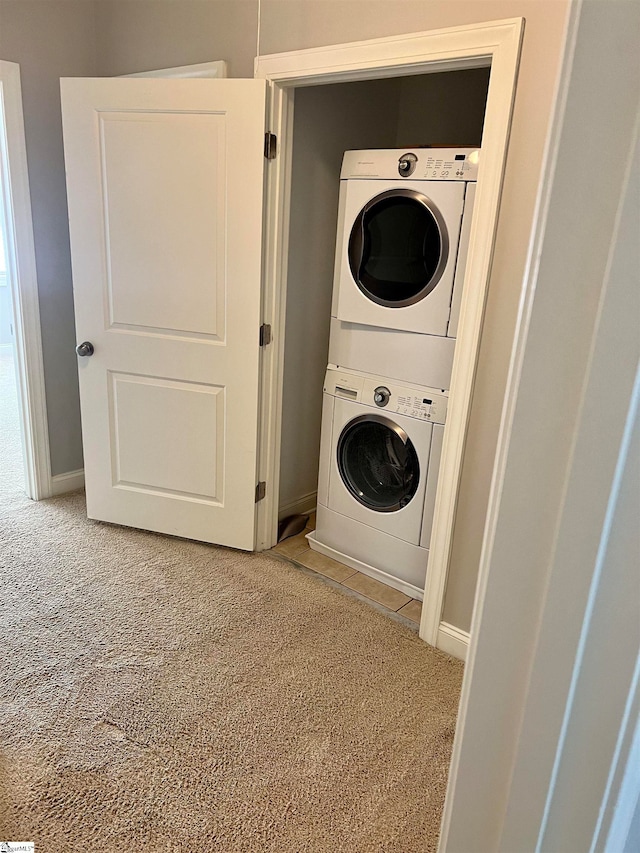 washroom featuring stacked washer and dryer and carpet