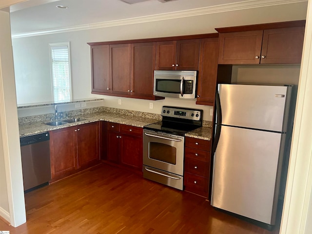 kitchen with sink, light stone countertops, dark hardwood / wood-style floors, appliances with stainless steel finishes, and ornamental molding