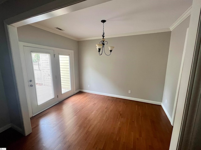 unfurnished dining area featuring ornamental molding, a notable chandelier, and wood-type flooring