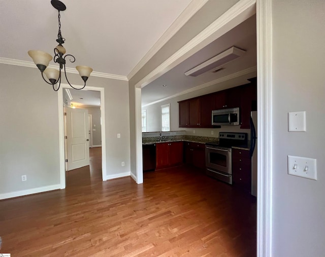 kitchen with stainless steel appliances, ornamental molding, a chandelier, and hardwood / wood-style flooring