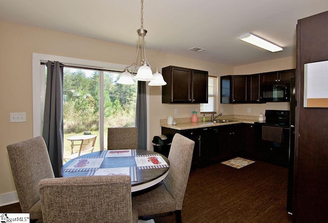 kitchen with dark brown cabinets, decorative light fixtures, dark hardwood / wood-style flooring, and black appliances