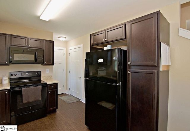 kitchen featuring dark brown cabinetry, dark hardwood / wood-style floors, and black appliances