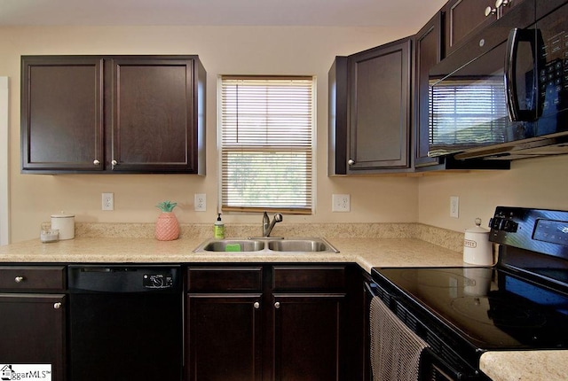 kitchen featuring dark brown cabinets, black appliances, a healthy amount of sunlight, and sink