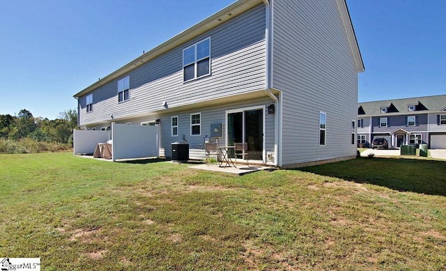 rear view of house featuring a yard, central AC, and a patio