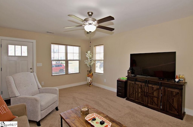 living room featuring light carpet, a healthy amount of sunlight, and ceiling fan