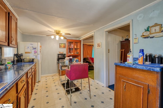 kitchen featuring ceiling fan, white refrigerator, and crown molding