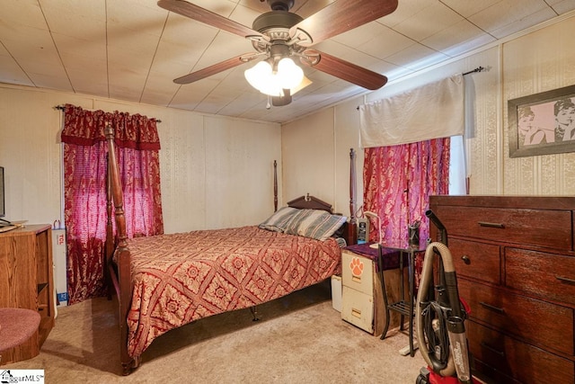 bedroom featuring light carpet, ornamental molding, and ceiling fan