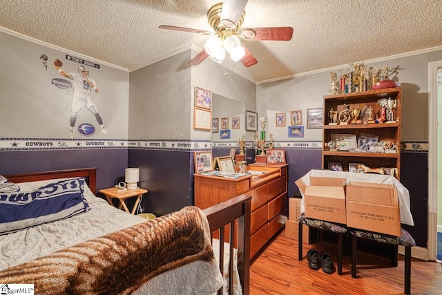 bedroom featuring crown molding, light hardwood / wood-style flooring, a textured ceiling, and ceiling fan