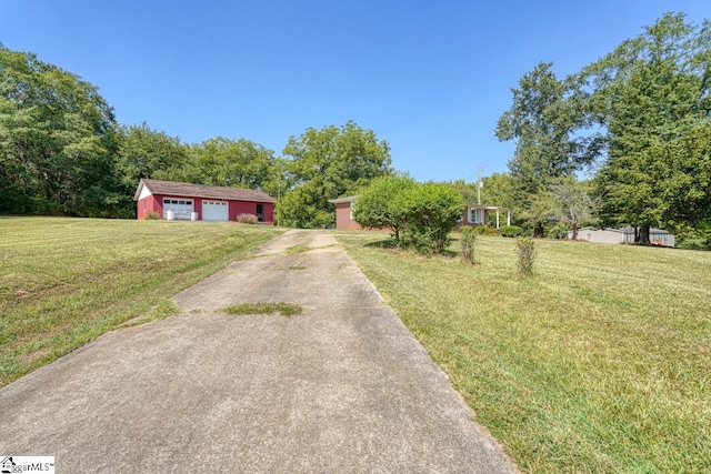 view of yard with a garage and an outbuilding