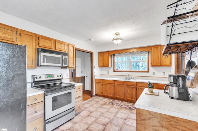 kitchen featuring a textured ceiling, sink, and appliances with stainless steel finishes