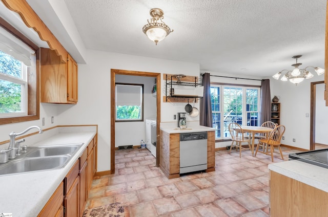 kitchen with a textured ceiling, dishwasher, sink, and a wealth of natural light